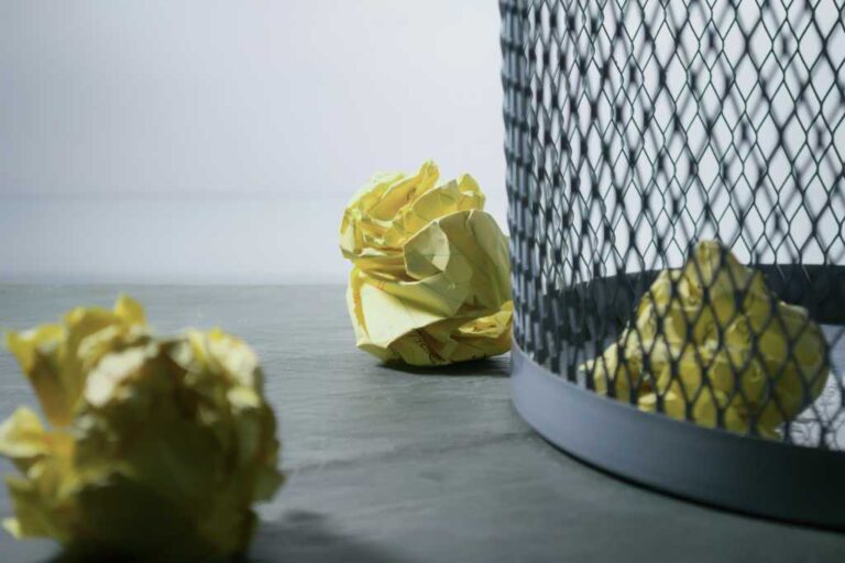 Yellow crumpled papers next to a waste basket.